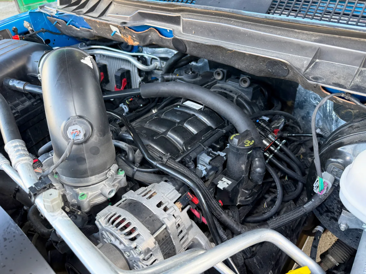 Под капотом Dodge Ram с установленным газобаллонным оборудованием: видны элементы ГБО, впускная система, генератор и двигатель.