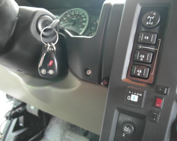 Кнопка переключения и индикации режимов работы ГБО в салоне Hummer H2 Limousine справа от рулевой колонки на центральной консоли