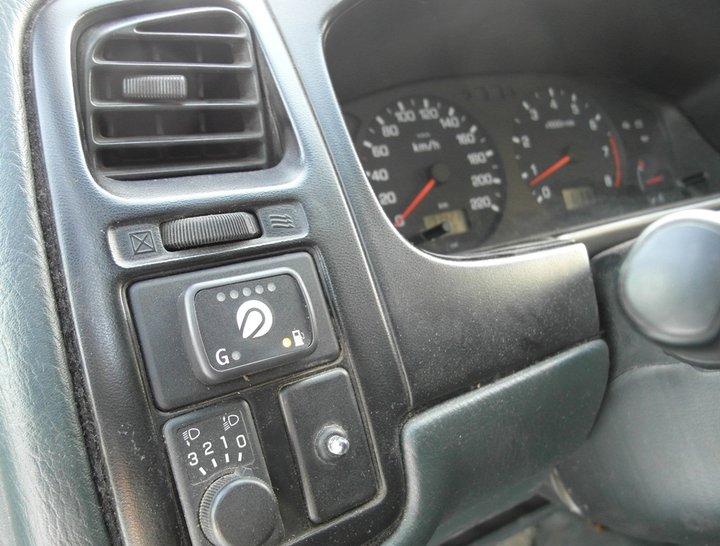 Кнопка переключения и индикации режимов работы ГБО с указателем уровня топлива слева от рулевой колонки Nissan Primera P11