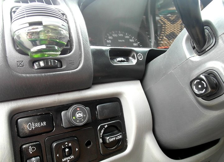 Кнопка переключения и индикации режимов работы BRC Sequent Plug&Drive с указателем уровня топлива слева от рулевой колонки Toyota Land Cruiser 100